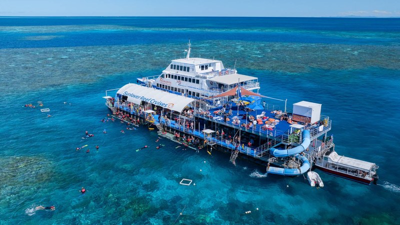 Pontoon and catamaran on the Great Barrier Reef near Cairns with snorkellers in turquoise water